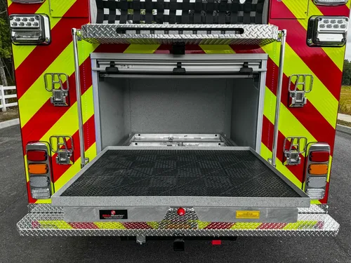 Rear compartment open three-quarter view with tailboard and interior shelf.